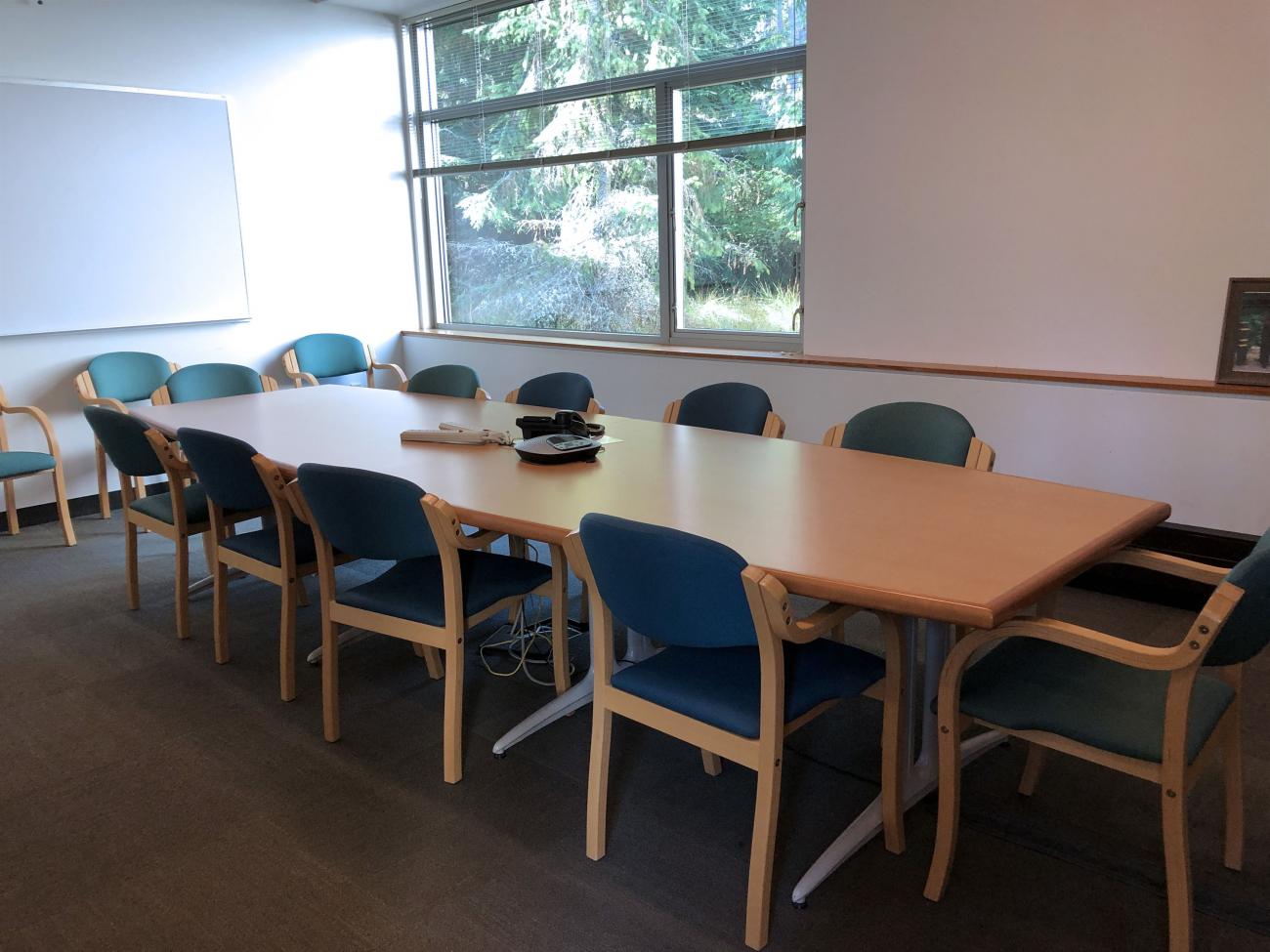 A smaller room with ten chairs located around a conference table.