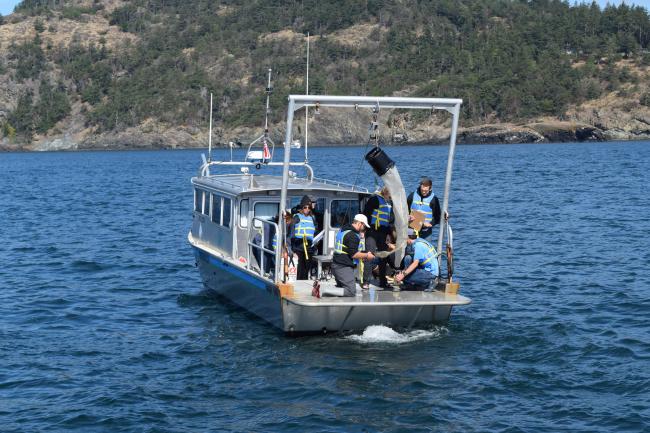 Students aboard a SPMC vessel collect samples with a plankton net.
